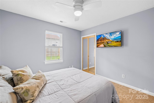 bedroom with baseboards, visible vents, carpet floors, ceiling fan, and a closet