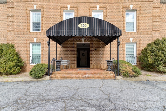 property entrance featuring brick siding