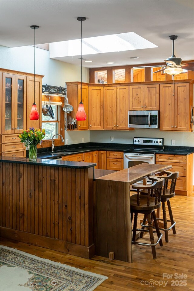 20 Meeks Rd, Black Mountain, NC 28711 - kitchen with light wood-style flooring, dark countertops, a sink, hanging light fixtures, and stainless steel appliances