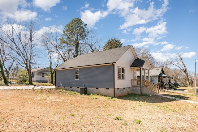 view of side of home featuring a shingled roof and crawl space