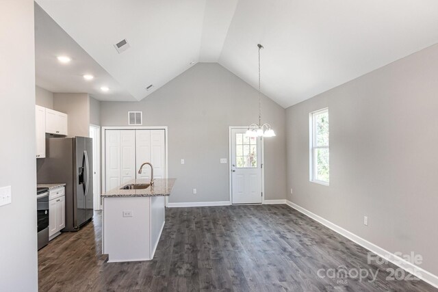 kitchen with visible vents, a center island with sink, stainless steel appliances, white cabinetry, and a sink