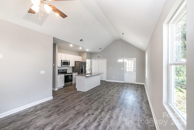 kitchen with a kitchen island with sink, ceiling fan with notable chandelier, open floor plan, stainless steel appliances, and white cabinets