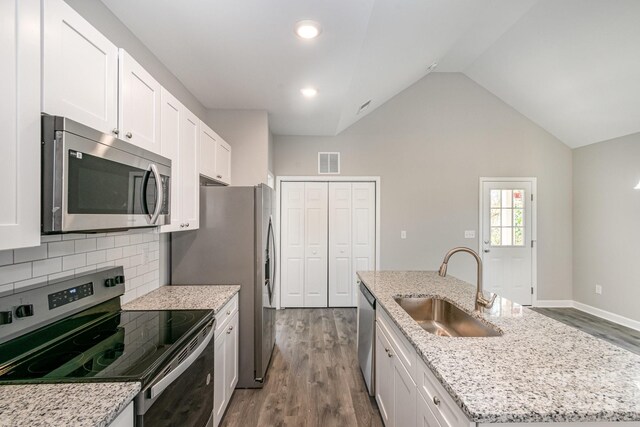 kitchen with visible vents, an island with sink, a sink, white cabinetry, and appliances with stainless steel finishes