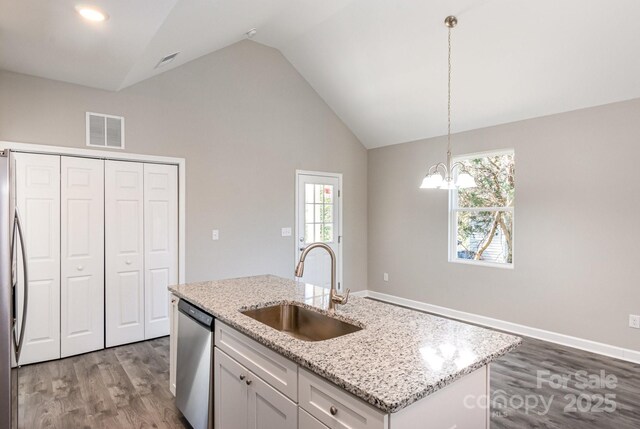 kitchen with visible vents, a sink, wood finished floors, stainless steel appliances, and vaulted ceiling