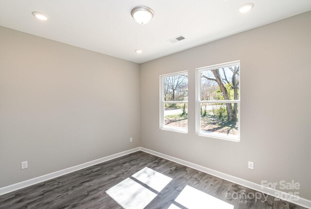 unfurnished room featuring visible vents, recessed lighting, baseboards, and dark wood-style flooring