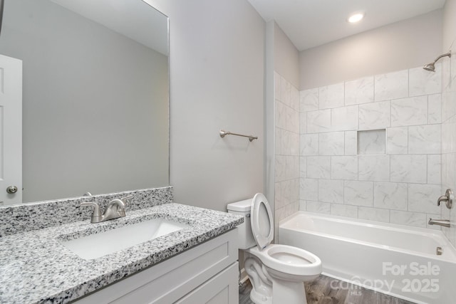 bathroom featuring shower / bath combination, toilet, wood finished floors, and vanity