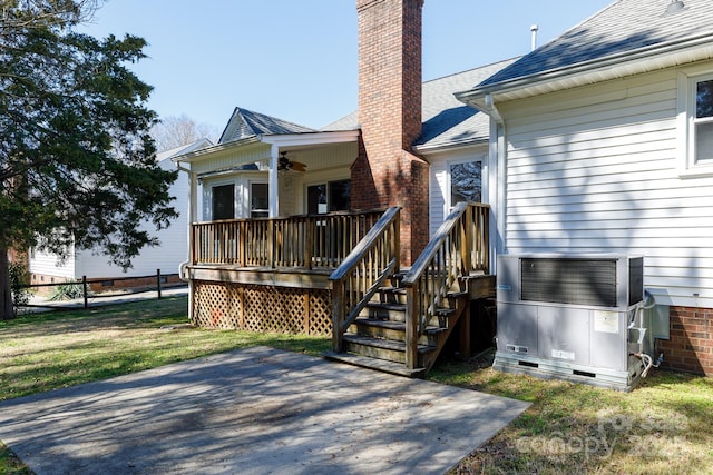 exterior space with crawl space, a yard, roof with shingles, and a chimney