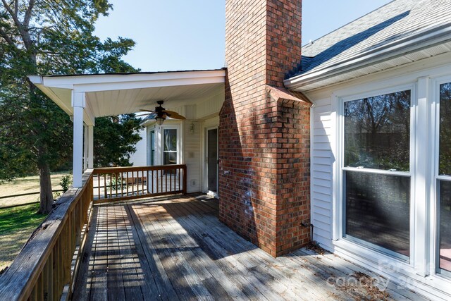 wooden terrace featuring a ceiling fan