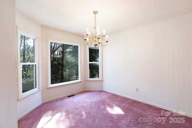 unfurnished room featuring visible vents, a textured ceiling, wallpapered walls, and carpet floors