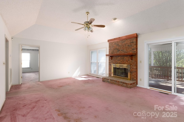 unfurnished living room with visible vents, a textured ceiling, carpet, a fireplace, and ceiling fan