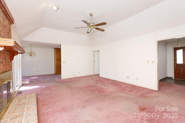 unfurnished living room featuring carpet, visible vents, vaulted ceiling, a brick fireplace, and ceiling fan with notable chandelier