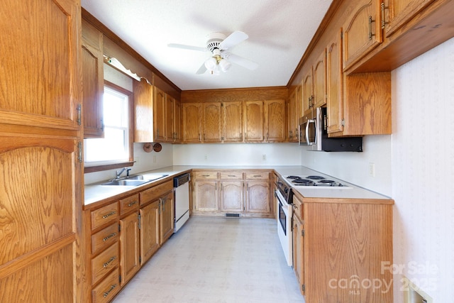 kitchen featuring light floors, white appliances, wallpapered walls, and light countertops