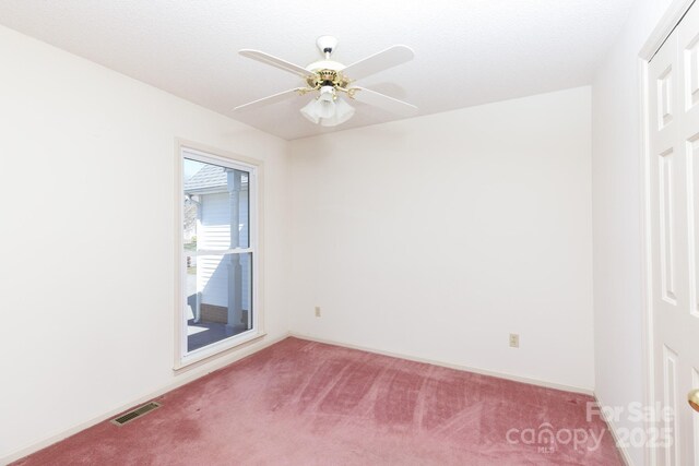 unfurnished room featuring visible vents, baseboards, ceiling fan, and carpet flooring