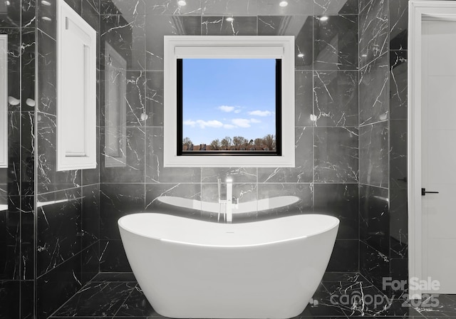 18601 Bluff Point Rd, Cornelius, NC 28031 - bathroom with a soaking tub, marble finish floor, and tile walls