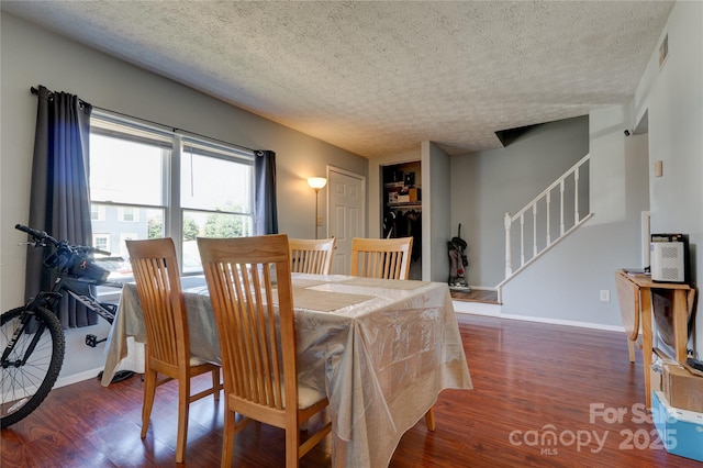 dining area featuring stairway, baseboards, and wood finished floors