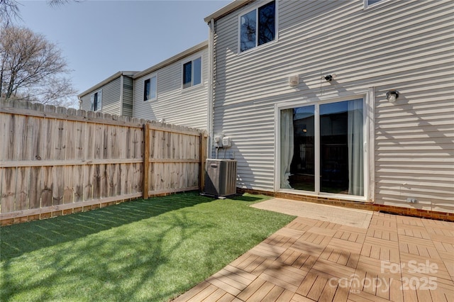 view of yard featuring central air condition unit and fence