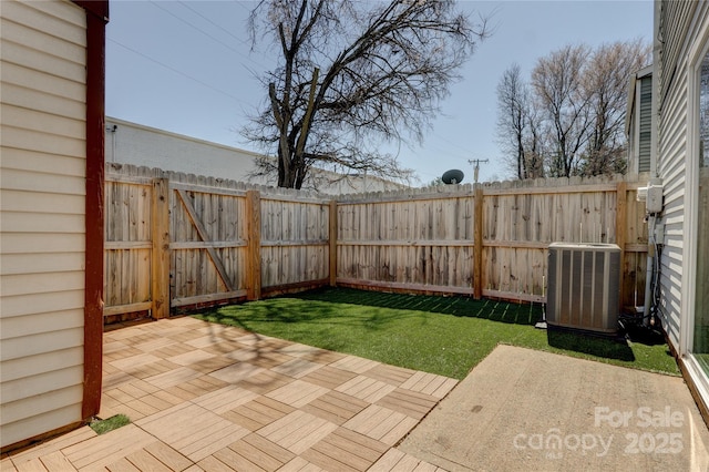 view of yard with cooling unit, fence, and a patio area