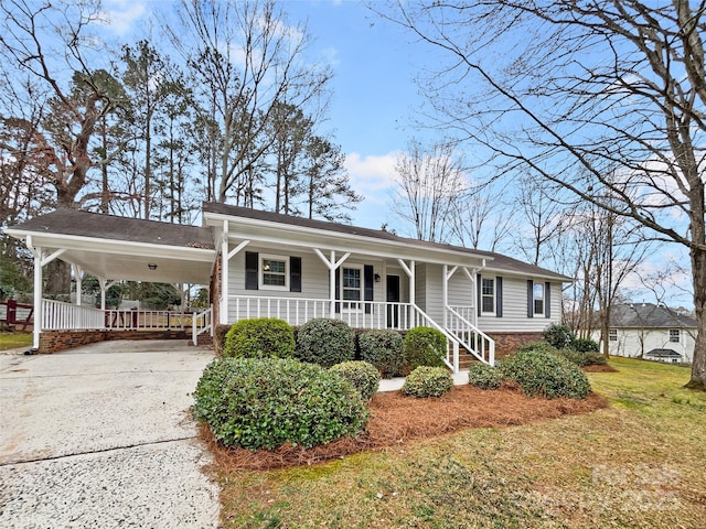 view of front of house with concrete driveway, a carport, covered porch, and a front yard