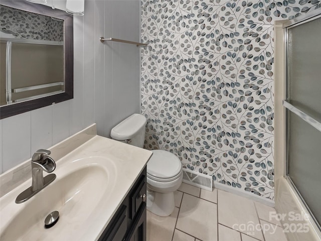 bathroom featuring visible vents, toilet, a shower with shower door, tile patterned floors, and vanity