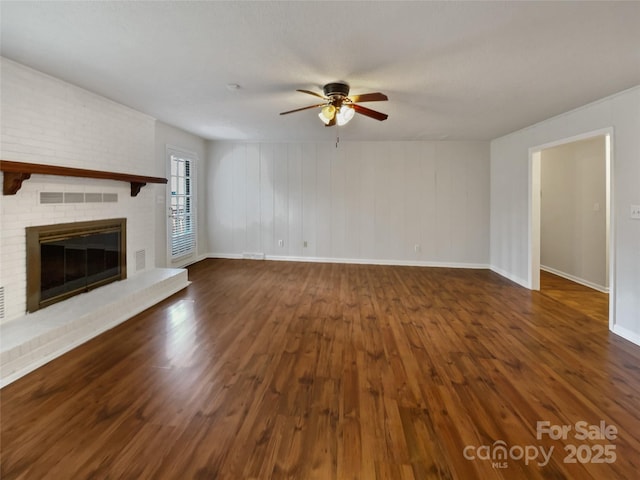 unfurnished living room with visible vents, dark wood finished floors, and a fireplace