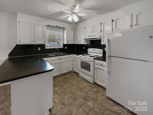 kitchen featuring dark countertops, under cabinet range hood, a peninsula, white appliances, and a sink