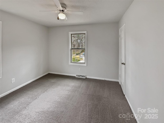 unfurnished room with baseboards, visible vents, ceiling fan, a textured ceiling, and dark carpet