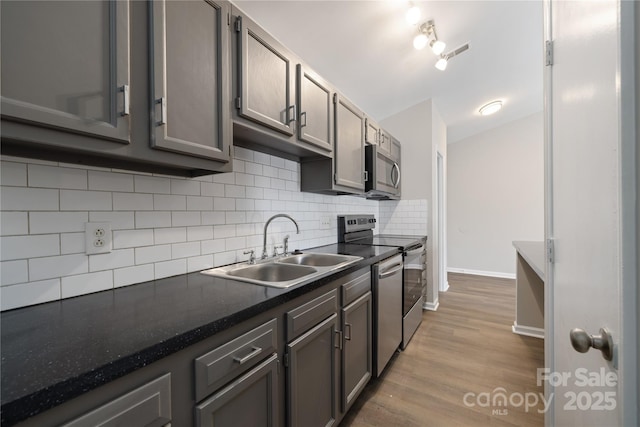 kitchen featuring tasteful backsplash, visible vents, dark countertops, appliances with stainless steel finishes, and a sink