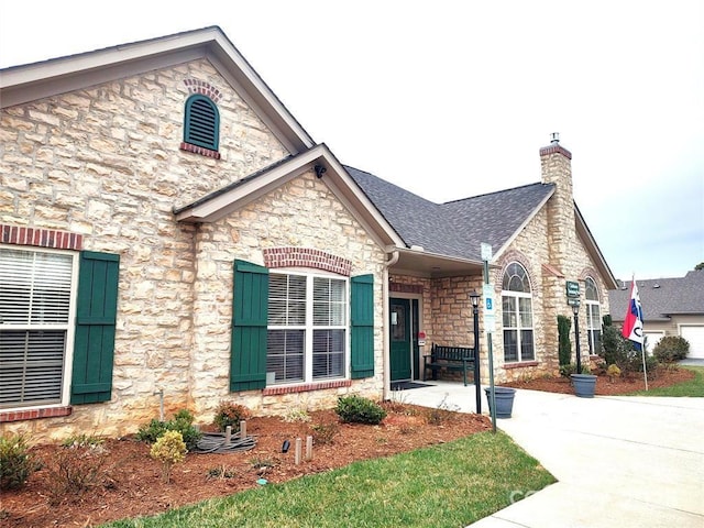 824 Wynnshire Dr Unit D, Hickory, NC 28601 - view of front of house featuring stone siding, a chimney, and roof with shingles