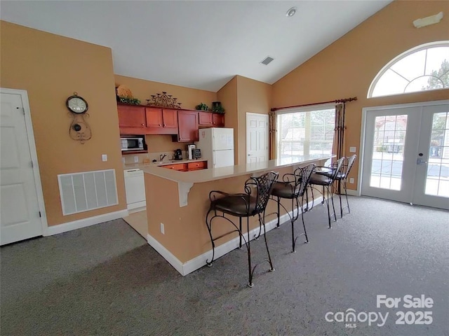 824 Wynnshire Dr Unit D, Hickory, NC 28601 - kitchen featuring white appliances, a breakfast bar, baseboards, plenty of natural light, and high vaulted ceiling