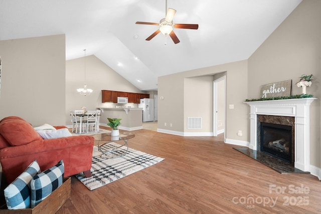 824 Wynnshire Dr Unit D, Hickory, NC 28601 - living room with light wood finished floors, vaulted ceiling, a ceiling fan, a high end fireplace, and a chandelier