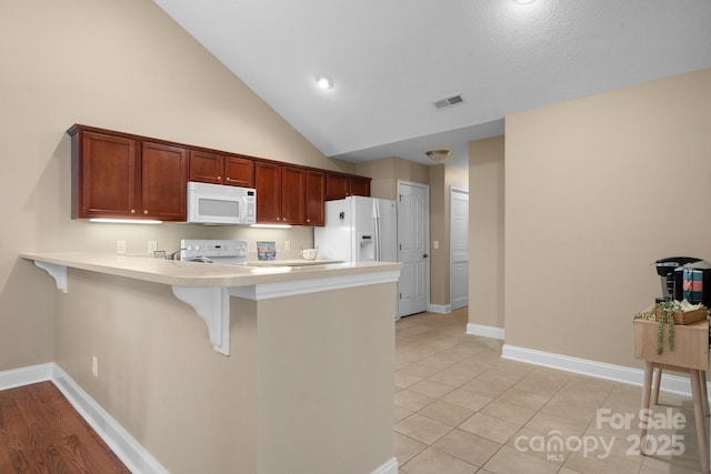 824 Wynnshire Dr Unit D, Hickory, NC 28601 - kitchen with white appliances, a breakfast bar, a peninsula, light countertops, and baseboards