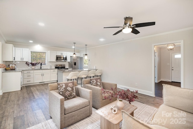 living room with ornamental molding, recessed lighting, light wood finished floors, baseboards, and ceiling fan