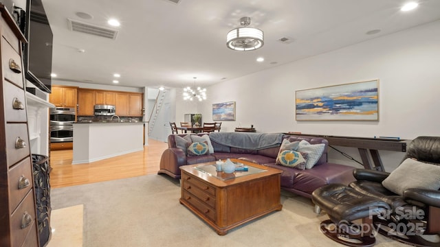 living room featuring visible vents, recessed lighting, and light colored carpet