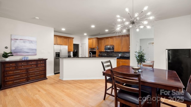 dining room with light wood finished floors, a notable chandelier, and recessed lighting