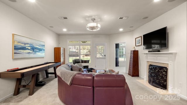 living room with recessed lighting, visible vents, light carpet, and a premium fireplace