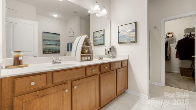 full bathroom featuring tile patterned flooring, double vanity, baseboards, and a sink