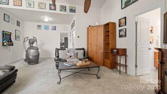 living area with light carpet and baseboards