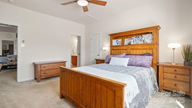 bedroom featuring light carpet, connected bathroom, attic access, and a ceiling fan