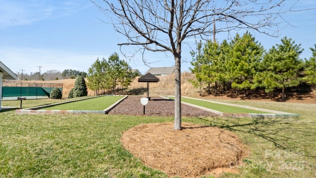 view of community with a yard and fence