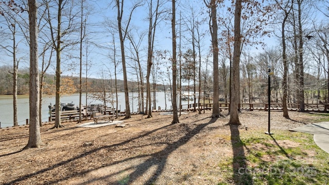 view of yard featuring a water view and fence