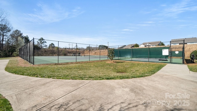 view of tennis court with a gate, a yard, and fence