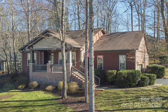 view of front of property with an attached garage, covered porch, and a front yard