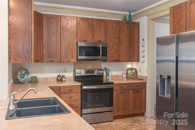 kitchen featuring appliances with stainless steel finishes, light countertops, and a sink