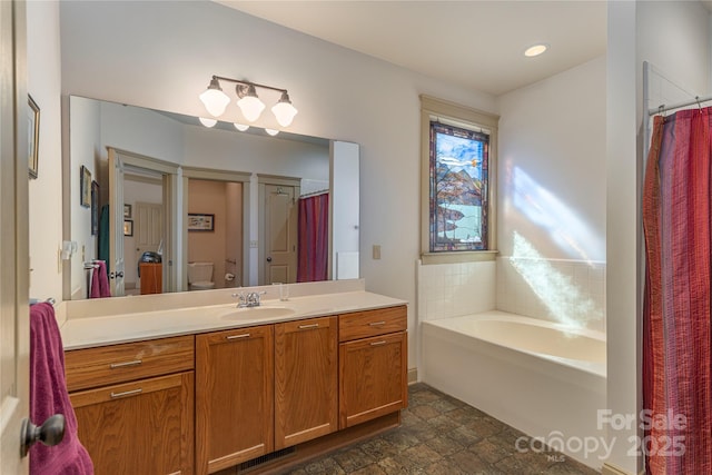 bathroom featuring visible vents, toilet, vanity, and a garden tub