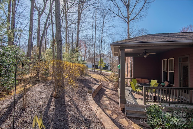 view of yard with a deck, outdoor lounge area, and a ceiling fan