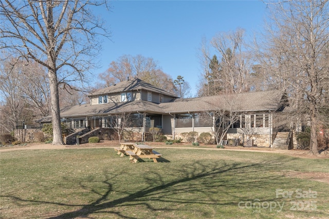 view of front of home featuring a front lawn and a sunroom