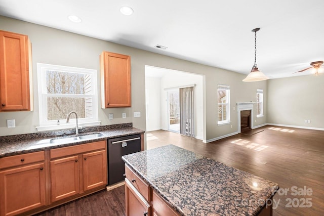 kitchen with dishwashing machine, dark stone countertops, dark wood-style flooring, a sink, and open floor plan