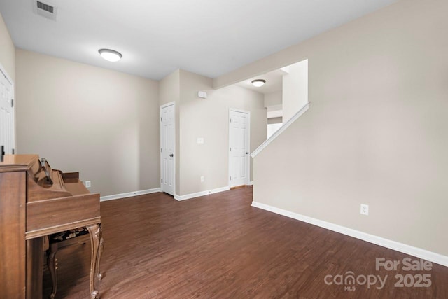 unfurnished living room with visible vents, baseboards, and wood finished floors