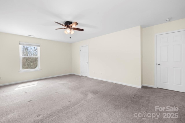 spare room with carpet flooring, visible vents, baseboards, and ceiling fan