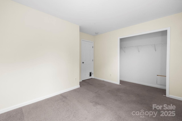 unfurnished bedroom with carpet, baseboards, and a closet